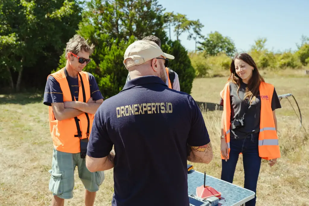 Dronexperts instructor training a drone remote pilot in the field