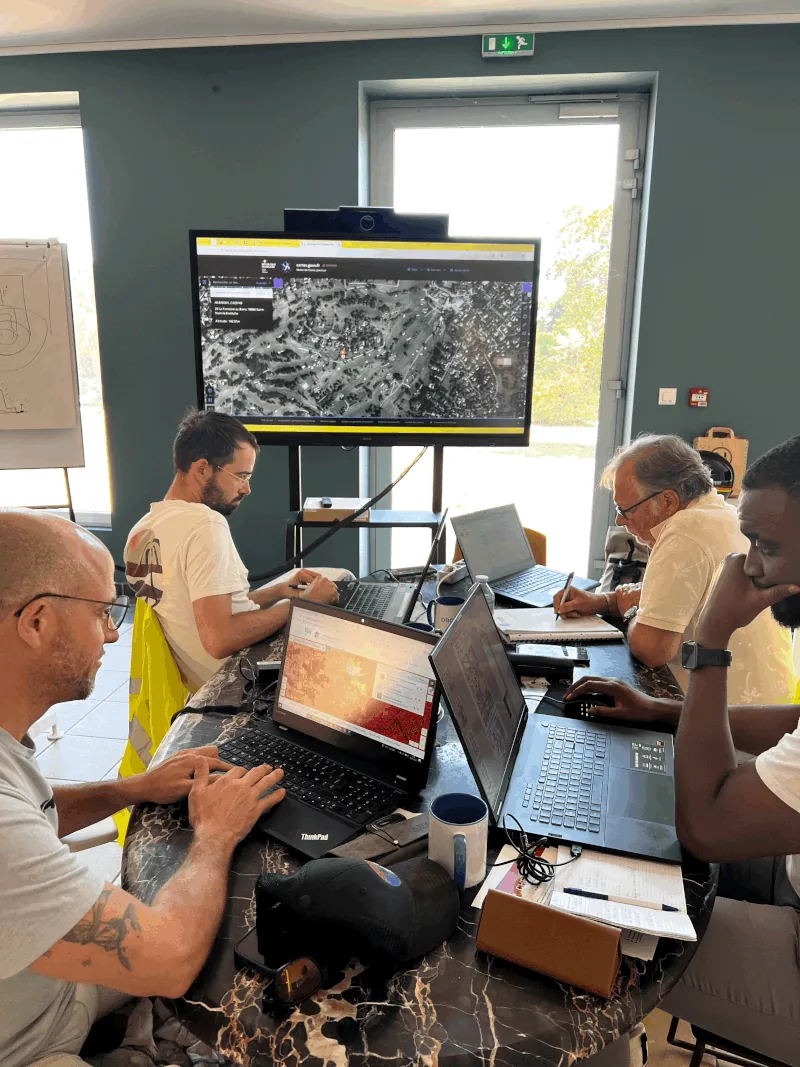 Stagiaires en préparation de mission sur ordinateur, carte aéronautique affichée à l'écran — formation de télépilote de drone Dronexperts