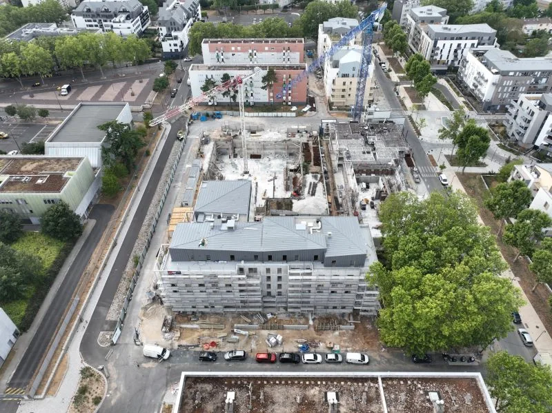 Suivi de chantier de construction par drone — vue aérienne des fondations et du gros œuvre d'un programme immobilier, deux grues en action, Dronexperts